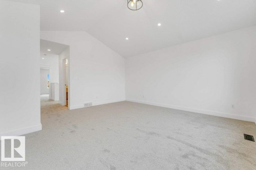 Spacious room featuring vaulted ceilings, recessed lighting, and a contemporary semi-flush mount fixture - 7403 Singer Landing Landing, Edmonton, AB - Indoor Photo Showing Other Room