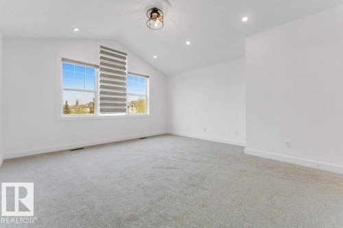 Bright room featuring an angled ceiling, recessed lighting, and a modern ceiling fixture - 7403 Singer Landing Landing, Edmonton, AB - Indoor Photo Showing Other Room