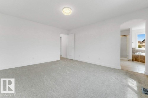Carpeted room with white walls, a single door, and a decorative ceiling light fixture - 7403 Singer Landing Landing, Edmonton, AB - Indoor Photo Showing Other Room