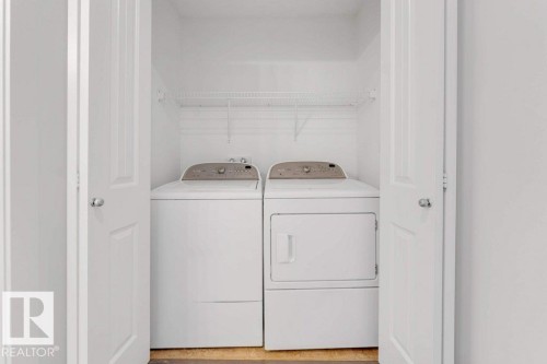 Dedicated laundry closet featuring a white top-load washer and front-load dryer - 7403 Singer Landing Landing, Edmonton, AB - Indoor Photo Showing Laundry Room