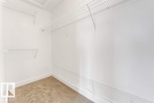 Walk-in closet featuring white wire shelving, white walls, white baseboards, and carpet flooring - 7403 Singer Landing Landing, Edmonton, AB - Indoor With Storage