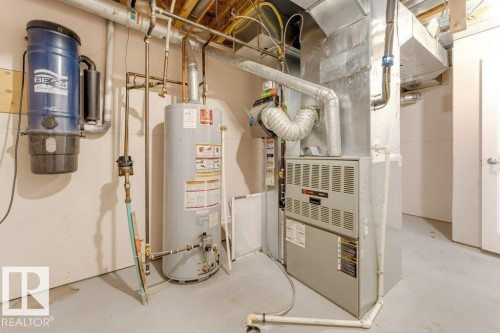 Dedicated utility space featuring a forced air furnace, hot water heater, and a central vacuum system - 7403 Singer Landing Landing, Edmonton, AB - Indoor Photo Showing Basement