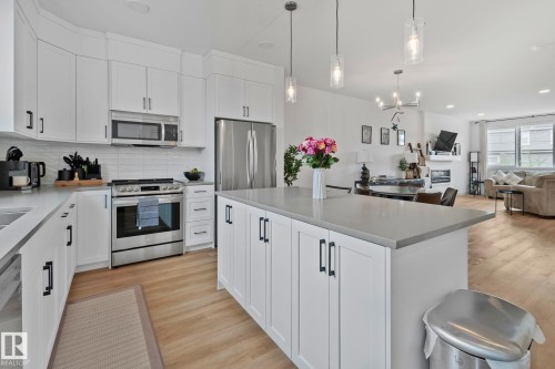 Kitchen featuring white shaker cabinetry, stainless steel appliances, light gray countertops, and an expansive center island with pendant lighting - 21027 130 Avenue, Edmonton, AB - Indoor Photo Showing Kitchen With Double Sink With Upgraded Kitchen