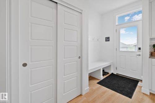 Entryway featuring wood-finish flooring, white built-in bench seating, storage cubbies, and a full-light door with transom window - 21027 130 Avenue, Edmonton, AB - Indoor Photo Showing Other Room