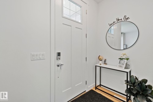 Entryway featuring a white paneled door with transom window, modern door hardware, and wood-finish flooring - 21027 130 Avenue, Edmonton, AB - Indoor Photo Showing Other Room