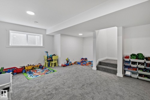 Finished basement space featuring plush grey carpeting, recessed lighting, and a white-trimmed window with blinds - 21027 130 Avenue, Edmonton, AB - Indoor