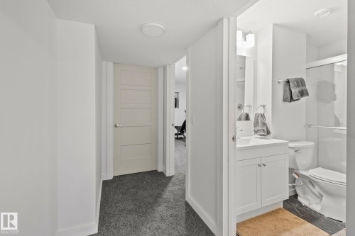 Modern bathroom with a single-sink vanity, white cabinetry, and an enclosed shower - 21027 130 Avenue, Edmonton, AB - Indoor Photo Showing Bathroom