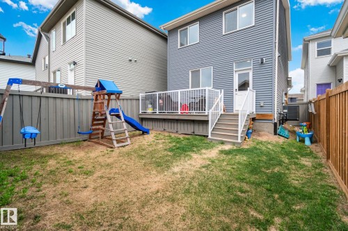 Rear exterior featuring grey siding and a ground-level deck with white railings - 21027 130 Avenue, Edmonton, AB - Outdoor With Deck Patio Veranda