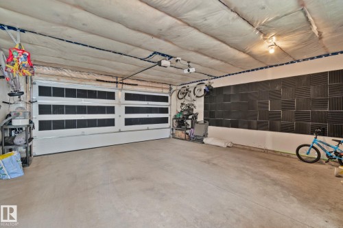 Spacious garage with a sectional overhead door and concrete flooring - 21027 130 Avenue, Edmonton, AB - Indoor Photo Showing Garage