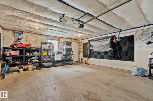 Spacious garage featuring a concrete floor, insulated ceiling, and overhead lighting - 21027 130 Avenue, Edmonton, AB - Indoor Photo Showing Garage
