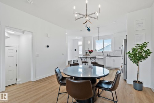 Open-concept dining area featuring wood-finish flooring, a contemporary chandelier, and recessed lighting - 21027 130 Avenue, Edmonton, AB - Indoor Photo Showing Dining Room
