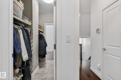 The hallway features rich hardwood flooring and leads to a tiled area - 26 Edgewater Terr N, St. Albert, AB - Indoor With Storage