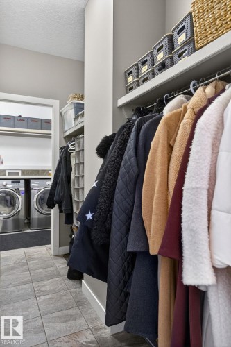 The property features a dedicated laundry area with tile flooring and a built-in shelf - 26 Edgewater Terr N, St. Albert, AB - Indoor With Storage