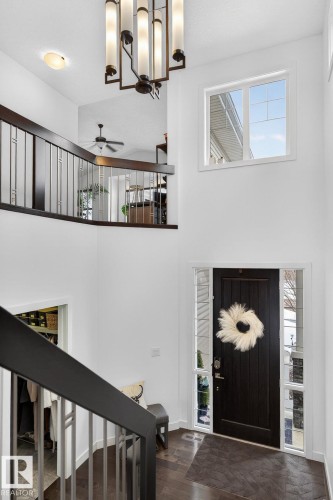 Welcoming entryway featuring a dark wood front door with sidelights, a contemporary chandelier, and hardwood flooring - 26 Edgewater Terr N, St. Albert, AB - Indoor Photo Showing Other Room