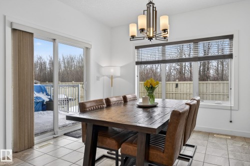 The dining area features tiled flooring, a large window, and a sliding glass door providing access to the outdoors - 26 Edgewater Terr N, St. Albert, AB - Indoor Photo Showing Dining Room