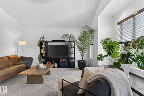 The living area features light gray carpet flooring, a large window with blinds, and recessed lighting - 26 Edgewater Terr N, St. Albert, AB - Indoor Photo Showing Living Room