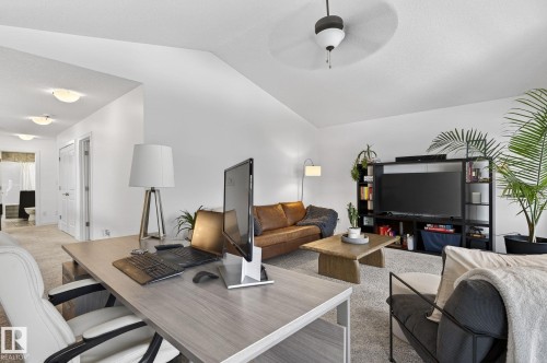 This open-concept living area features a light-colored carpet, a ceiling fan, and white walls - 26 Edgewater Terr N, St. Albert, AB - Indoor