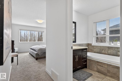 The bedroom features a large window, providing natural light and views of trees - 26 Edgewater Terr N, St. Albert, AB - Indoor Photo Showing Other Room