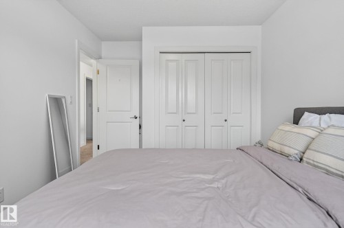 Bedroom featuring white walls, a white door, and white closet doors with dark hardware - 26 Edgewater Terr N, St. Albert, AB - Indoor Photo Showing Bedroom