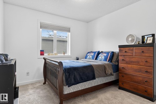 This room features neutral-toned carpeting, white walls, and a window providing natural light - 26 Edgewater Terr N, St. Albert, AB - Indoor Photo Showing Bedroom