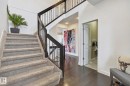 Inviting entryway featuring dark hardwood flooring, a carpeted staircase with dark wood and metal railings, and a doorway leading to an additional space - 26 Edgewater Terr N, St. Albert, AB  - Indoor Photo Showing Other Room 