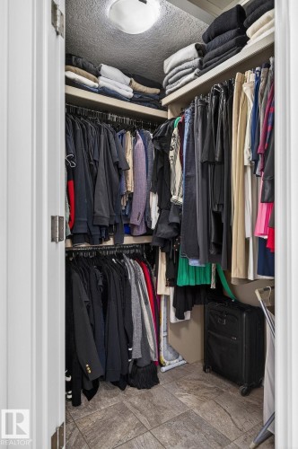 The property features a walk-in closet with built-in shelving, hanging rods, and tile flooring - 26 Edgewater Terr N, St. Albert, AB - Indoor With Storage