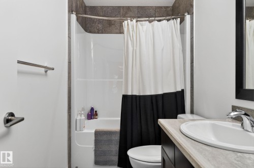 Bathroom featuring a vanity with an integrated sink and chrome faucet, a toilet, and a shower-tub combination with tiled surround - 26 Edgewater Terr N, St. Albert, AB - Indoor Photo Showing Bathroom