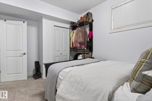 The property features a room with light-colored carpeting, a window with blinds, and white doors - 26 Edgewater Terr N, St. Albert, AB - Indoor Photo Showing Bedroom