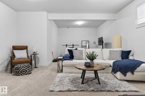 The property features an expansive living area with neutral carpeting and white walls - 26 Edgewater Terr N, St. Albert, AB - Indoor Photo Showing Living Room