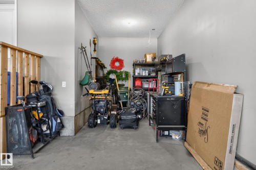 This property features a garage with grey walls, a concrete floor, and a textured ceiling - 26 Edgewater Terr N, St. Albert, AB - Indoor Photo Showing Other Room