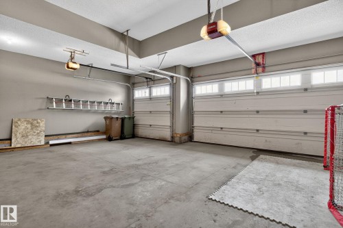 Spacious garage featuring concrete flooring and two garage doors with upper window panels - 26 Edgewater Terr N, St. Albert, AB - Indoor Photo Showing Garage