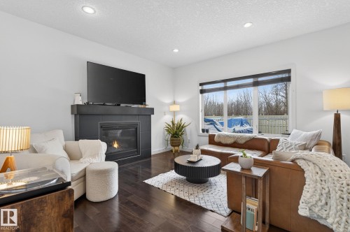 Living area featuring dark hardwood floors, a fireplace with a dark surround, and recessed lighting - 26 Edgewater Terr N, St. Albert, AB - Indoor Photo Showing Living Room With Fireplace