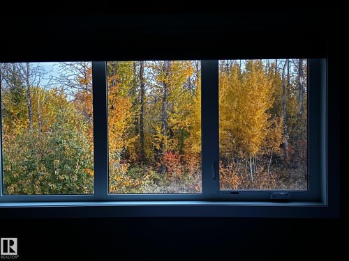 The property offers expansive window views of surrounding trees with vibrant autumn foliage - 26 Edgewater Terr N, St. Albert, AB - 