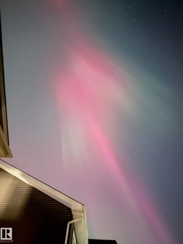 The property features a dark-colored exterior with light-colored trim and a visible gutter system - 26 Edgewater Terr N, St. Albert, AB - 