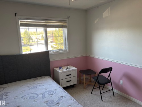 Carpeted room with a multi-pane window and horizontal blinds - 3516 49 Avenue, Drayton Valley, AB - Indoor Photo Showing Bedroom