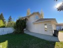 Stucco exterior featuring an arched entryway, shingle roofing, and an attached garage with a single window - 3516 49 Avenue, Drayton Valley, AB  - Outdoor 