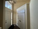 Foyer featuring a high transom window, paneled entry door with sidelight, overhead flush mount light fixture, and bifold panel closet doors - 3516 49 Avenue, Drayton Valley, AB  - Indoor Photo Showing Other Room 