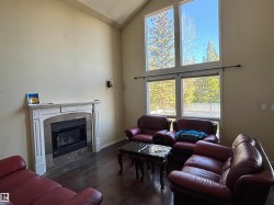 Living area featuring a floor-to-ceiling fireplace with a stone surround and white mantel - 