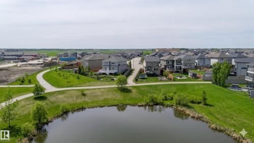 Neighborhood featuring a paved walking path, green spaces, and a pond - 62 Ellice Bend, Fort Saskatchewan, AB - Outdoor With Body Of Water With View