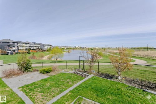 Expansive backyard featuring a manicured lawn, a paved patio, and a black chain-link fence - 62 Ellice Bend, Fort Saskatchewan, AB - Outdoor With View