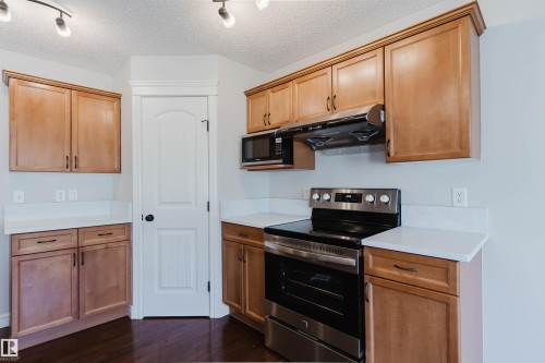 Kitchen featuring wood cabinetry, white countertops, a stainless steel range, and a built-in microwave - 1140 115 Street, Edmonton, AB - Indoor Photo Showing Kitchen