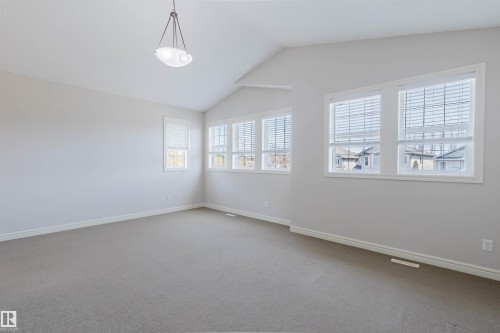 Spacious room featuring vaulted ceilings, neutral-toned walls, and plush carpeting - 1140 115 Street, Edmonton, AB - Indoor Photo Showing Other Room