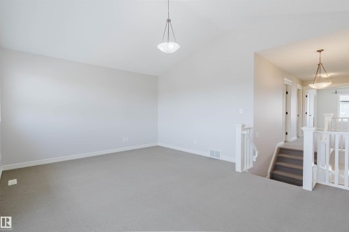 Spacious interior room featuring vaulted ceilings, light neutral wall paint, and gray carpet flooring - 1140 115 Street, Edmonton, AB - Indoor Photo Showing Other Room