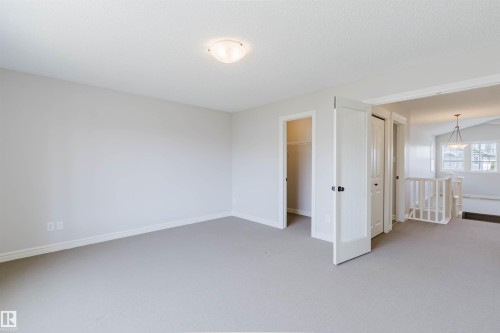 Spacious room with light gray carpeting, white baseboards, and a semi-flush ceiling light fixture - 1140 115 Street, Edmonton, AB - Indoor Photo Showing Other Room