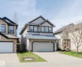 Two-story residence featuring a two-car garage, stone accents, tan siding, and dark trim - 1140 115 Street, Edmonton, AB  - Outdoor With Facade 