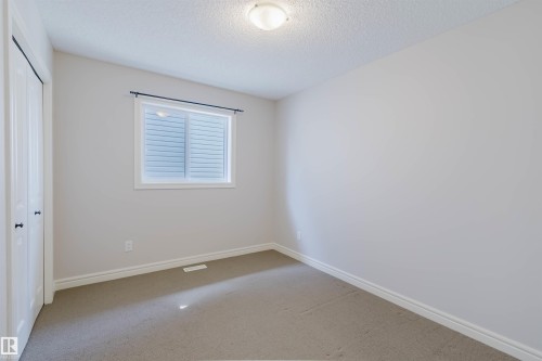 Neutral-toned room featuring a single window with blinds, light gray wall paint, and coordinating carpeted flooring - 1140 115 Street, Edmonton, AB - Indoor Photo Showing Other Room