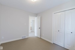 Neutral color palette room featuring light grey walls, white baseboards, and carpeted flooring - 