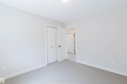 Neutral-toned interior with light grey walls, light grey carpeting, and white baseboards - 1140 115 Street, Edmonton, AB - Indoor Photo Showing Other Room