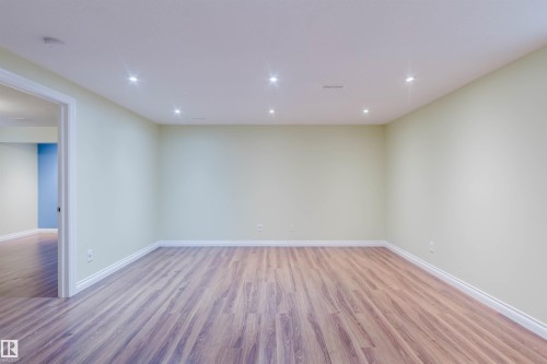 Expansive interior space featuring wood-finish flooring, recessed lighting, light-toned wall paint, and white baseboards - 1140 115 Street, Edmonton, AB - Indoor Photo Showing Other Room