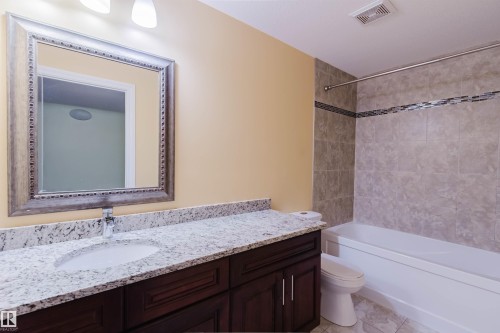 Bathroom featuring a dark wood-finish vanity with a white countertop and integrated sink - 1140 115 Street, Edmonton, AB - Indoor Photo Showing Bathroom